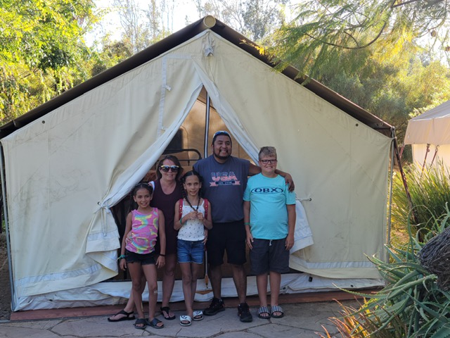 Laylah and her family standing in front of their tent in San Diego